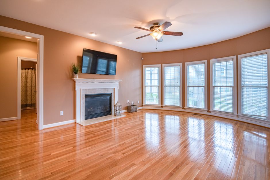 Close-up of a light-colored laminate floor with a wooden edge, showing a clean and smooth surface devoid of dust or stains, illuminated by soft natural lighting. Part of a rectangular section of the l